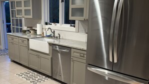 A modern kitchen with stainless steel appliances, a built-in sink, and a patterned rug. - Southern Vermont Retreat w/ Hot Tub, Fire Pit, & Bunk Room (Windham)