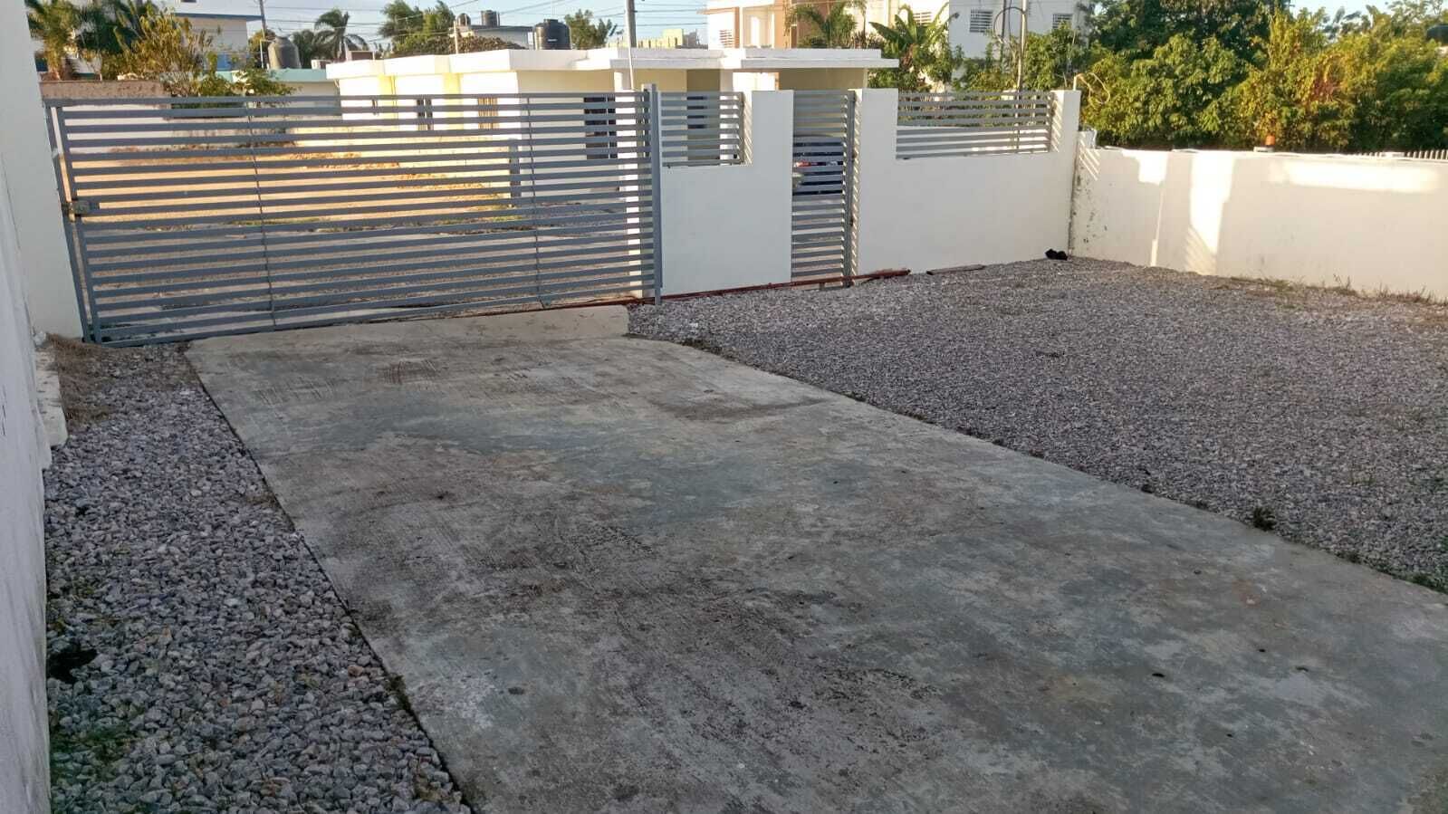 Terrassa al terrat amb paviment de formigó, grava i una porta metàl·lica.