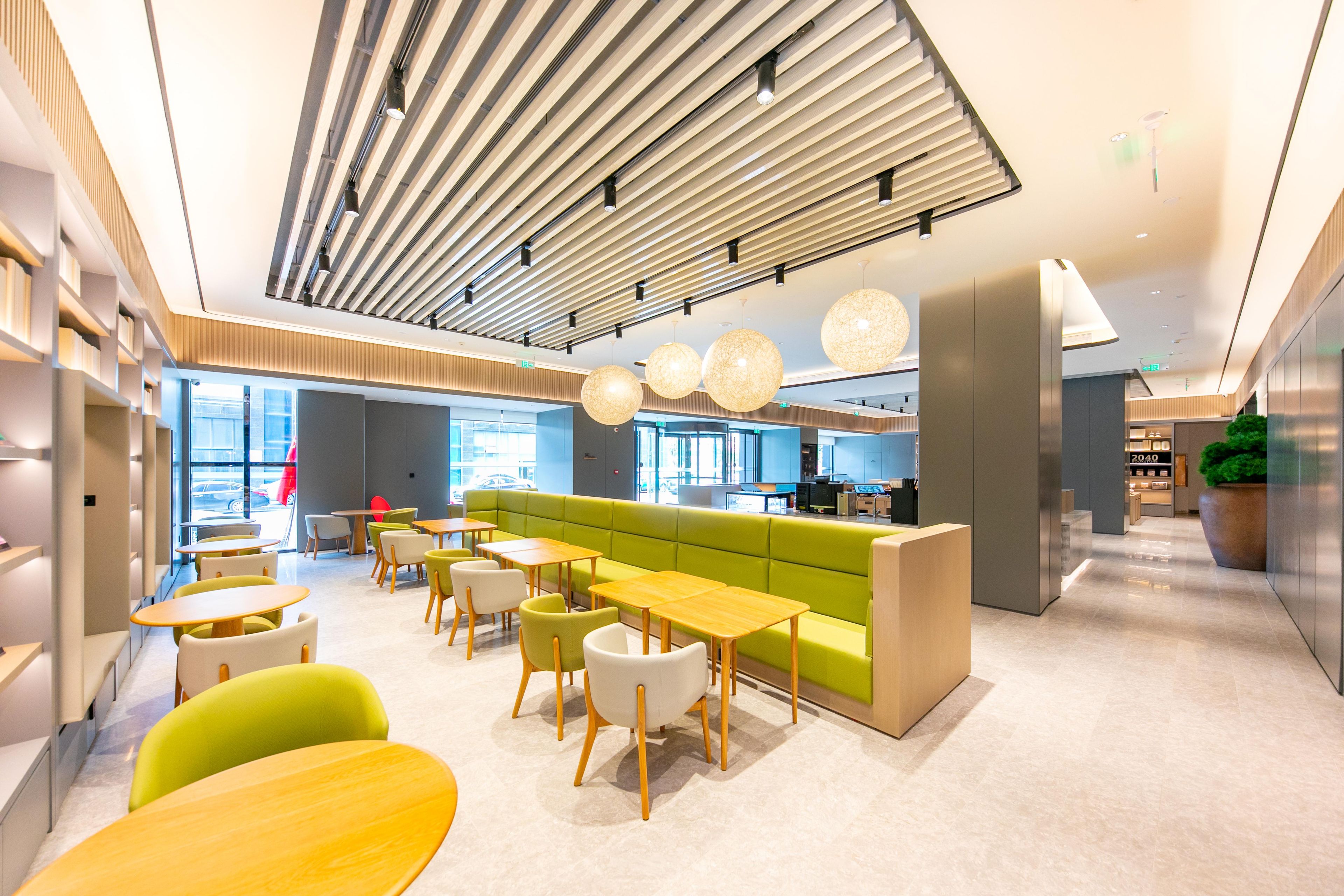 Un interior moderno con un sofá verde, sillas amarillas y blancas, y una mesa de madera.