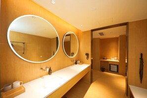 Une salle de bain moderne avec deux lavabos, de grands miroirs et un meuble-lavabo en bois.
