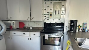 Una cocina con armarios blancos, horno de acero inoxidable y salpicadero de azulejos.