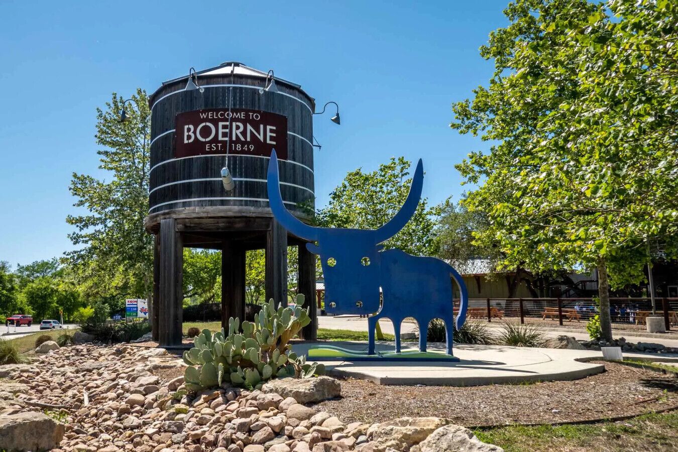 A water tower with a sign reading "Welcome to Boerne, Est. 1849" and a blue sculpture of a bull.