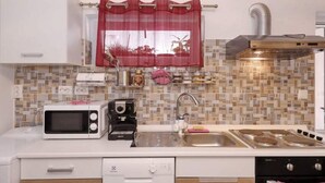 A compact kitchen with a microwave, toaster, sink, and dishwasher.