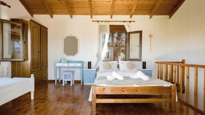A bedroom with a wooden bed, a desk, a wardrobe, and a mirror.