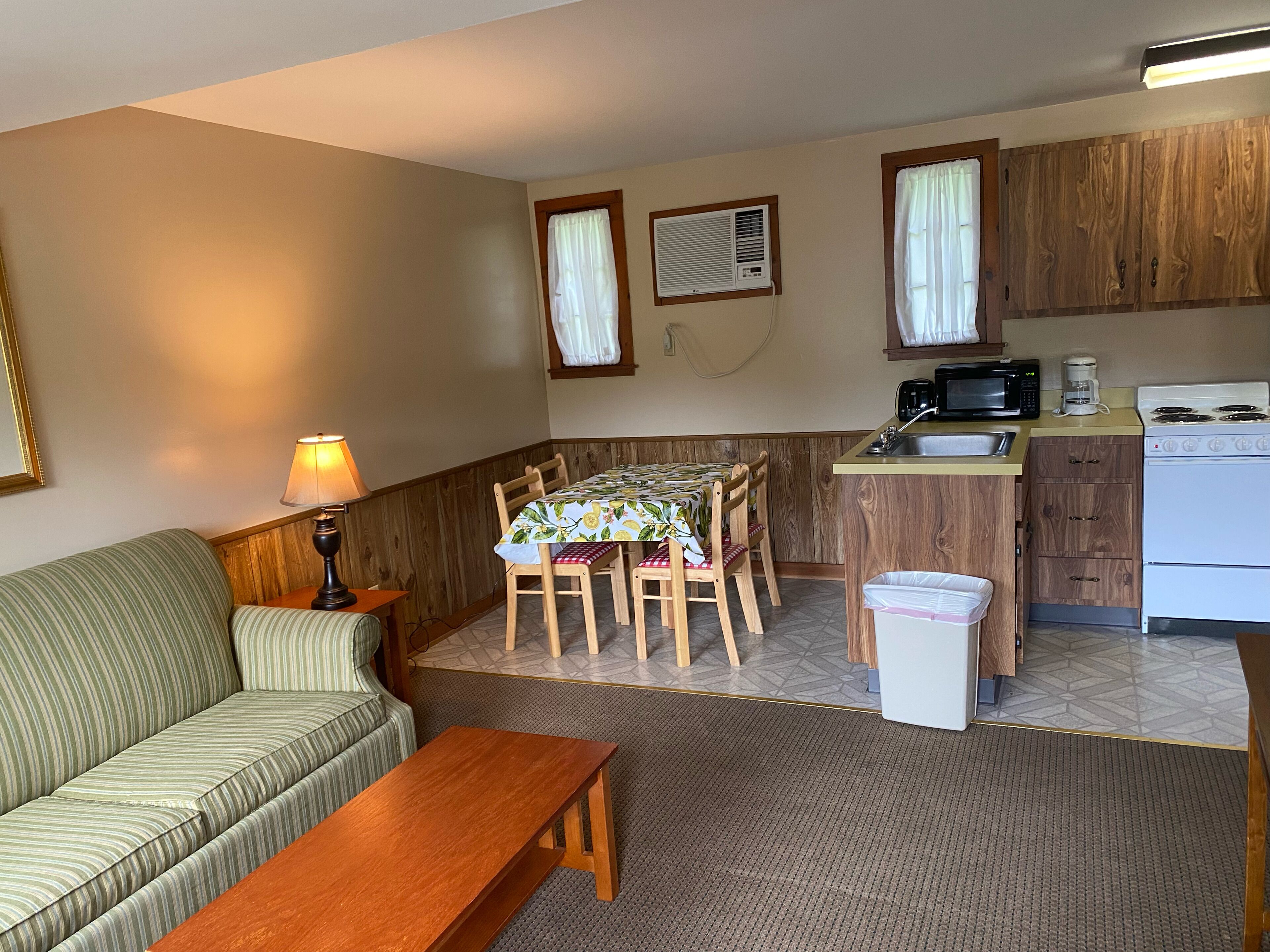 A compact living space with a sofa, dining table, and kitchenette.