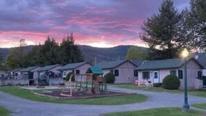 Un camping con cabañas tipo autocaravana, un parque infantil y cielo despejado.