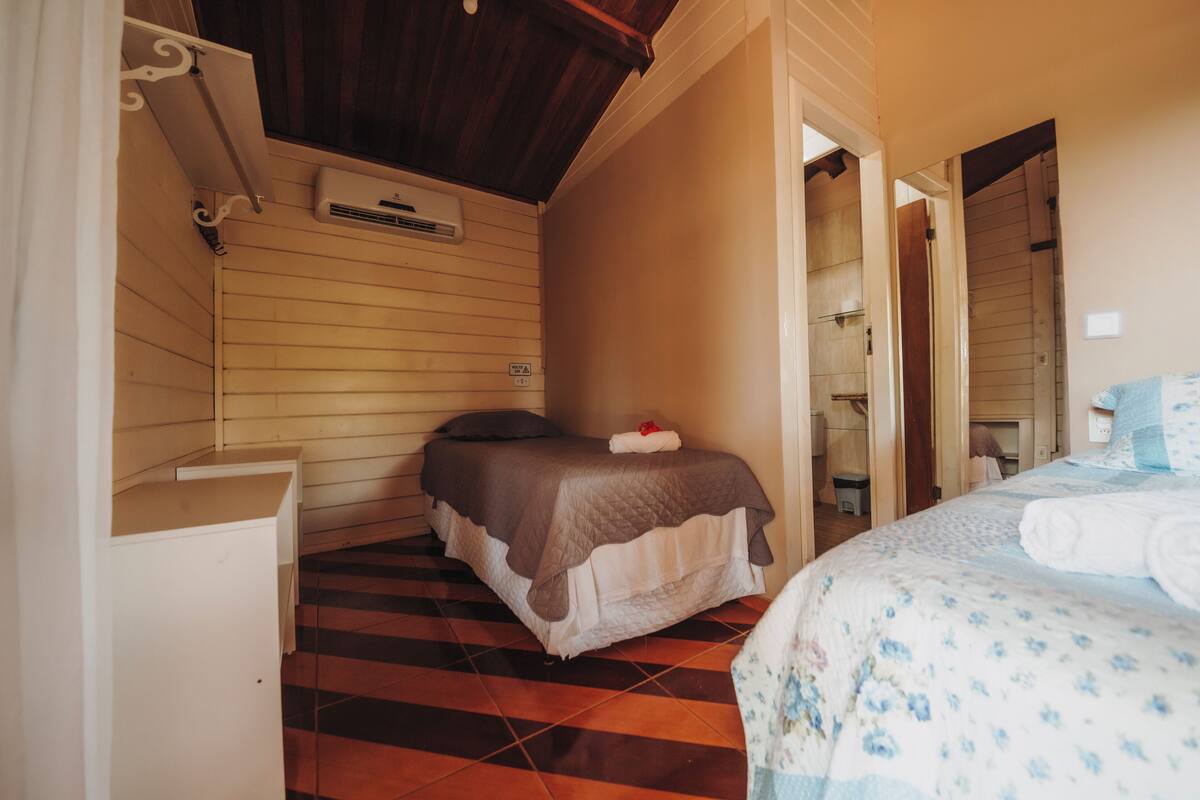 Una camera da letto con un letto, una cassettiera e uno specchio.