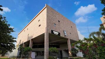 A modern building with a sign reading "PALETTE." It features a brick facade, multiple windows, and a covered entrance area with steps leading up to it.
