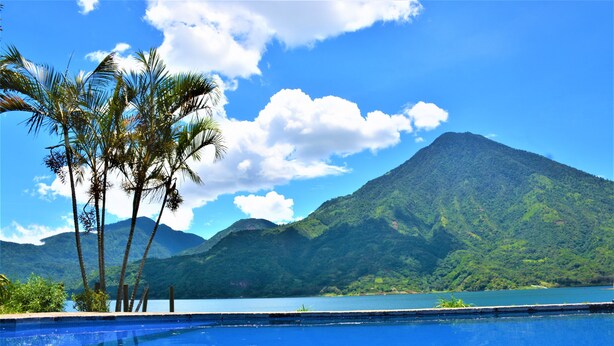 Una piscina con el paisaje de una montaña al fondo.