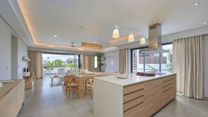A modern kitchen with a central island, dining area, and large windows. - Penthouse Blue Horizon, 5 min Mont Choisy beach (Trou-aux-Biches)