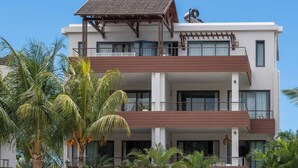 A modern multi-story building with balconies, large windows, and a satellite dish. - Penthouse Blue Horizon, 5 min Mont Choisy beach (Trou-aux-Biches)