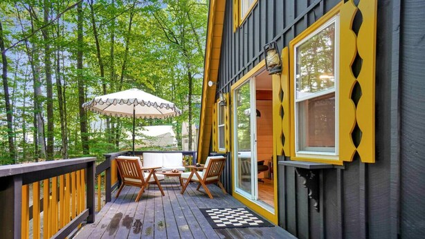 A wooden deck with a checkered mat, two wooden chairs, and a table. - Relaxing A-Frame with Hot Tub and Lake Access (Denmark)