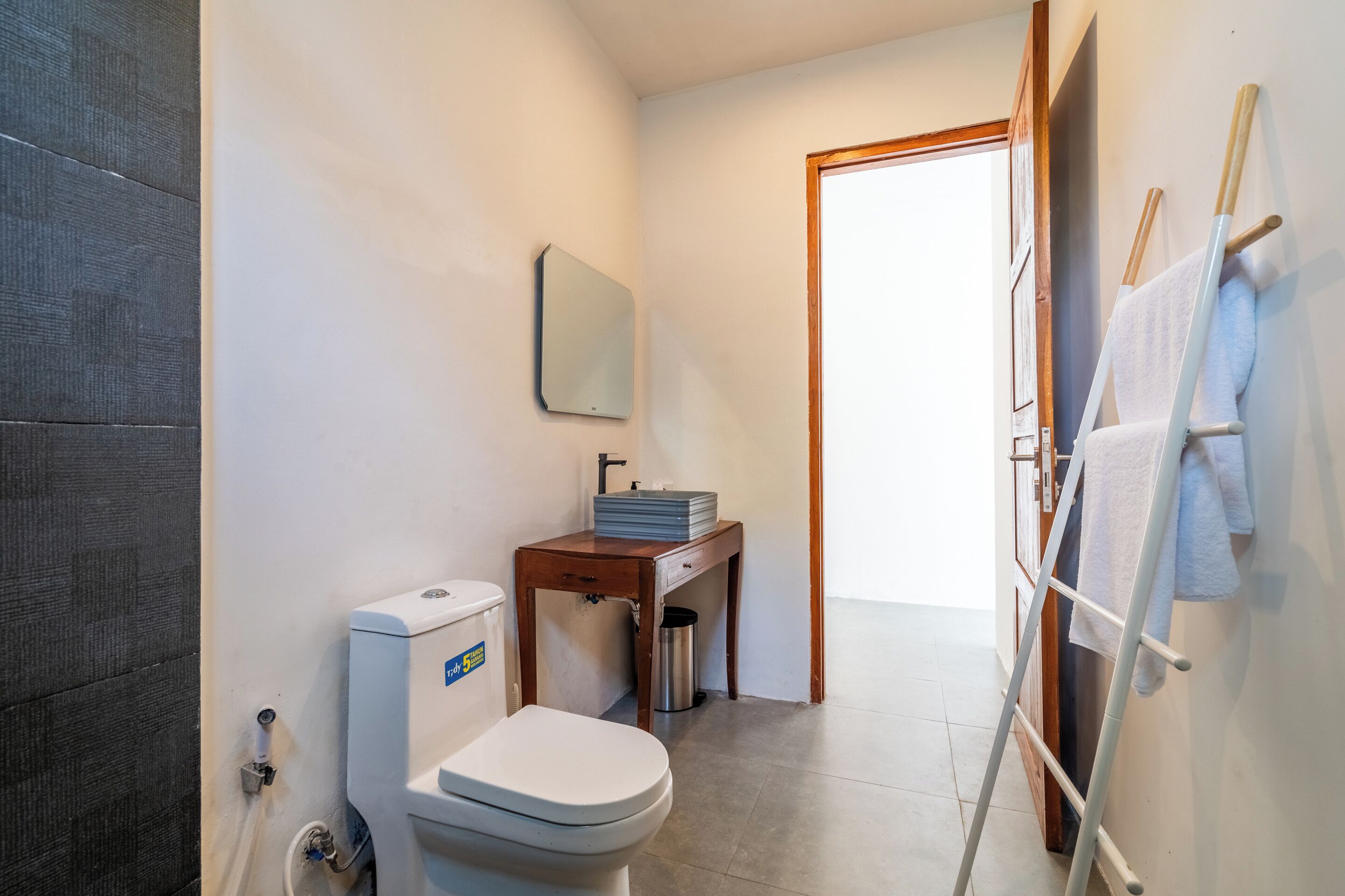 Ein Badezimmer mit Toilette, Waschbecken und einem Spiegel an der Wand.