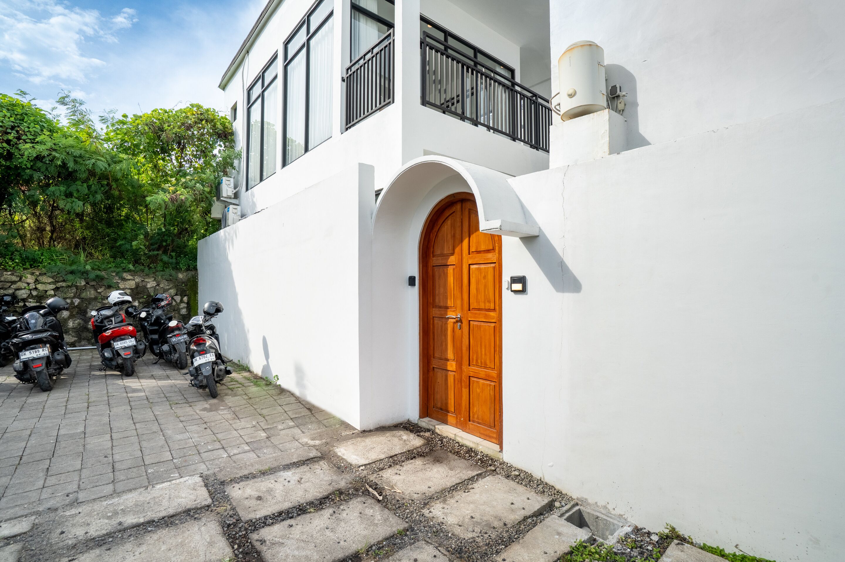 Un edificio blanco con puerta de madera y un balcón.