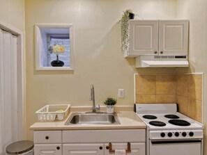 The kitchen inside the unit equipped with refrigerator, stove, coffee maker, and other cooking essentials so guests can prepare their own meals