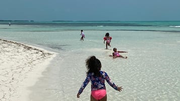 Una playa cerca, arena blanca, toallas de playa, kayak