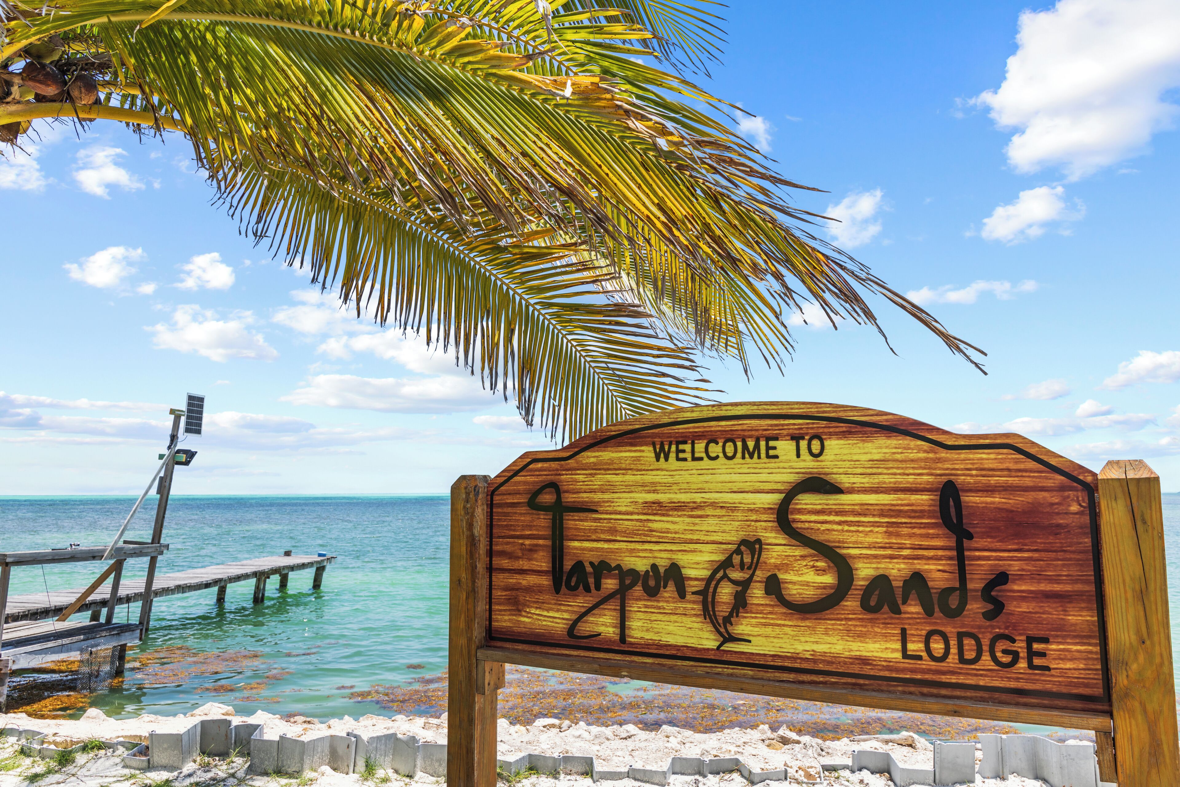 A wooden sign with 'Welcome to Larpun Sands Lodge' written on it.