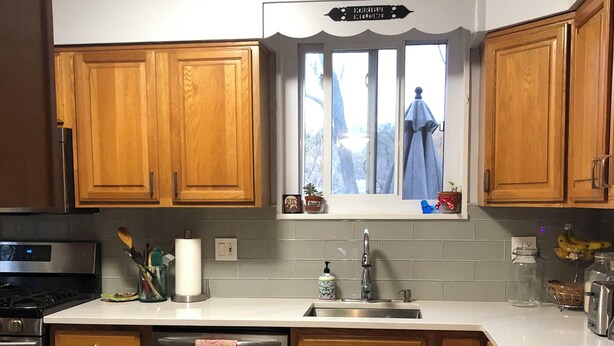 A kitchen with wooden cabinets, a stainless steel sink, and a window with a view of the outdoors. - Comfortable home in Alexandria, walkable to Old Town / Metro, close to DC (Alexandria)