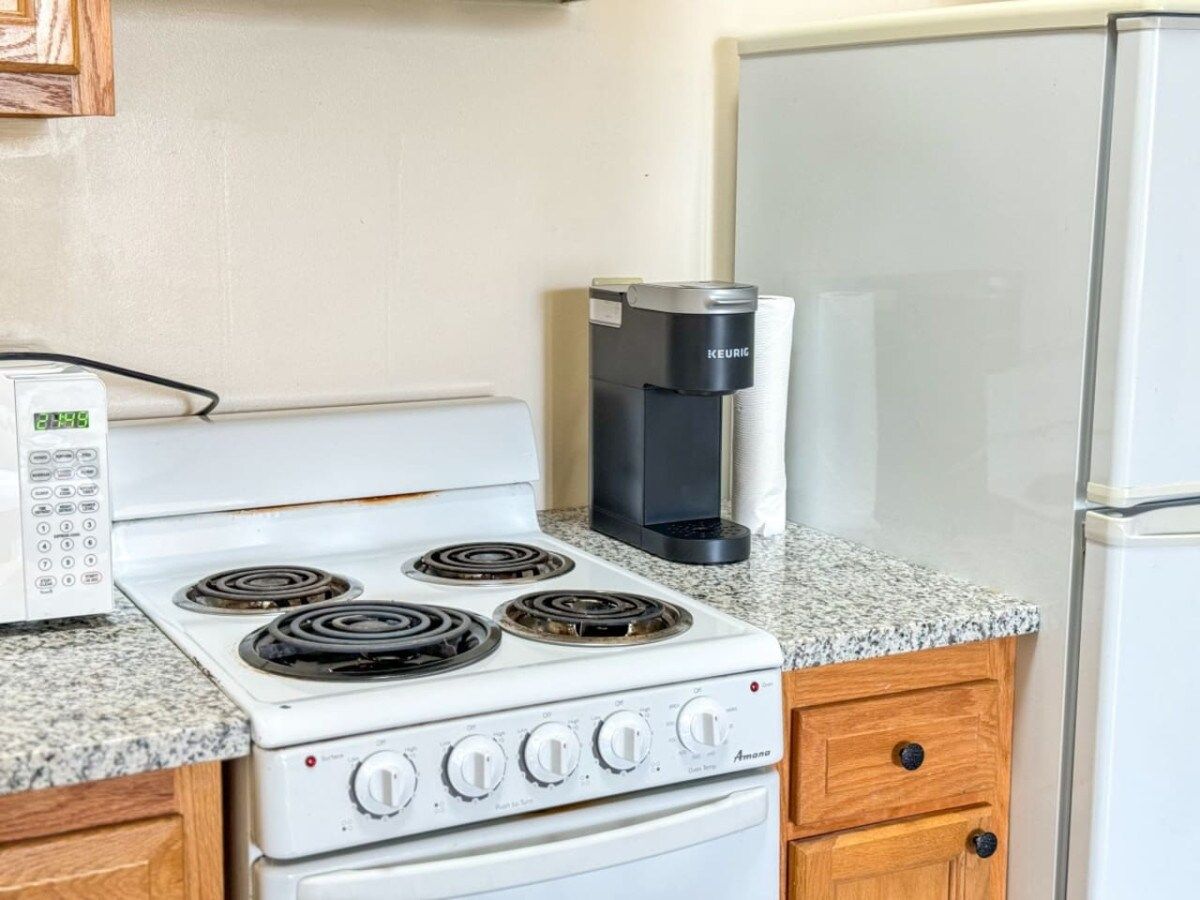 Kitchen with refrigerator, stove, microwave and coffee machine