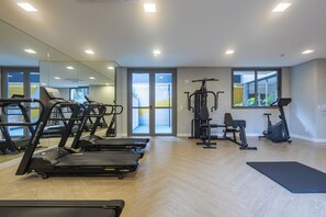 A modern gym with treadmills, a weight machine, and an elliptical. - 360 Horizon Paraíso (Sao Paulo)