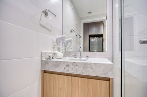 A modern bathroom with a marble countertop, a hairdryer, and a towel. - 360 Horizon Paraíso (Sao Paulo)