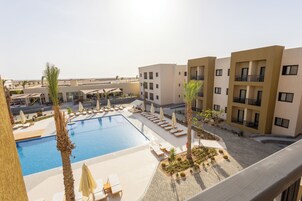 Un hotel con piscina, tumbonas y vistas al desierto.