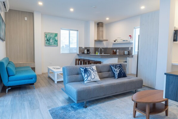 A modern living room with a sofa, a coffee table, and a small wooden table.