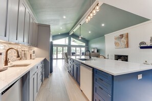Una cucina moderna con un'isola grande, elettrodomestici integrati e vista sull'area pranzo.