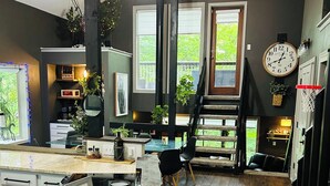 Una cocina moderna con una isla central, piso de madera y ventanas amplias.