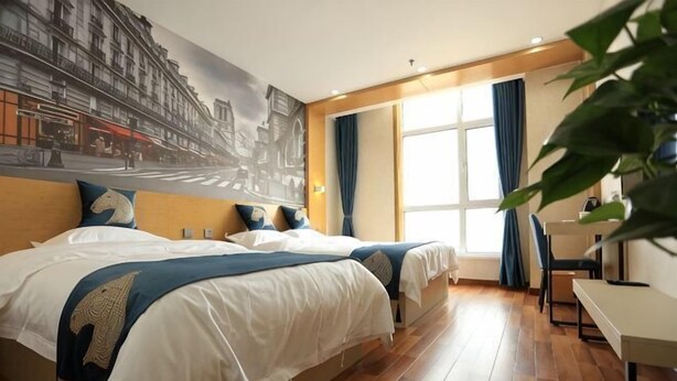 Habitación de hotel con dos camas, un escritorio, una silla, un ventanal con cortinas y un mural en la pared.