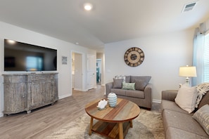 Relax in this inviting living room with a flat-screen TV, comfortable sofa, and decorative coffee table.