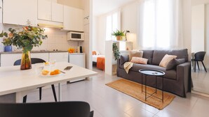 Un appartement moderne comprenant une cuisine, un coin repas et un salon.