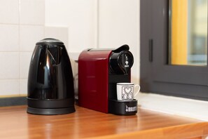 Una cafetera y un electrodoméstico rojo sobre una encimera de cocina.