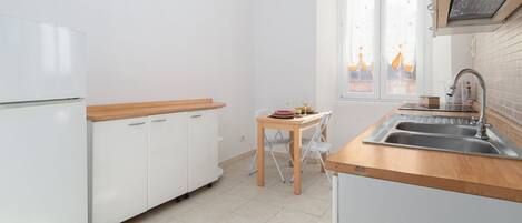 Kylskåp, spishäll, kaffe- och tebryggare och grytor/köksredskap