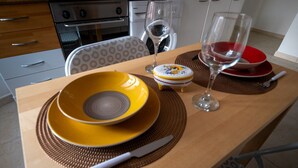 A dining table with yellow and red plates, a knife, and two wine glasses. - Don Leandro's House by Rentbeat (Civitavecchia)