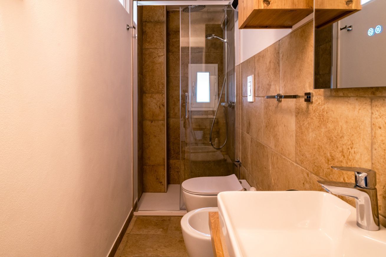A bathroom with a shower, toilet, and sink.