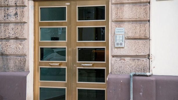 A double door with multiple windows, a sign indicating 'CONDOMINIO VIA REBARDI 42', and a utility pipe on the adjacent wall. - Casa Sinatra by Rentbeat (Taranto)