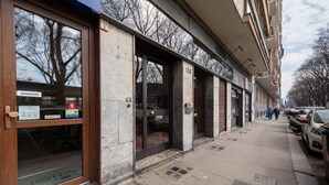 A building with a large glass entrance, a sign for 'SPINGERE,' and a visible door number '138.' - Casa Peschiera by Rentbeat (Torino)