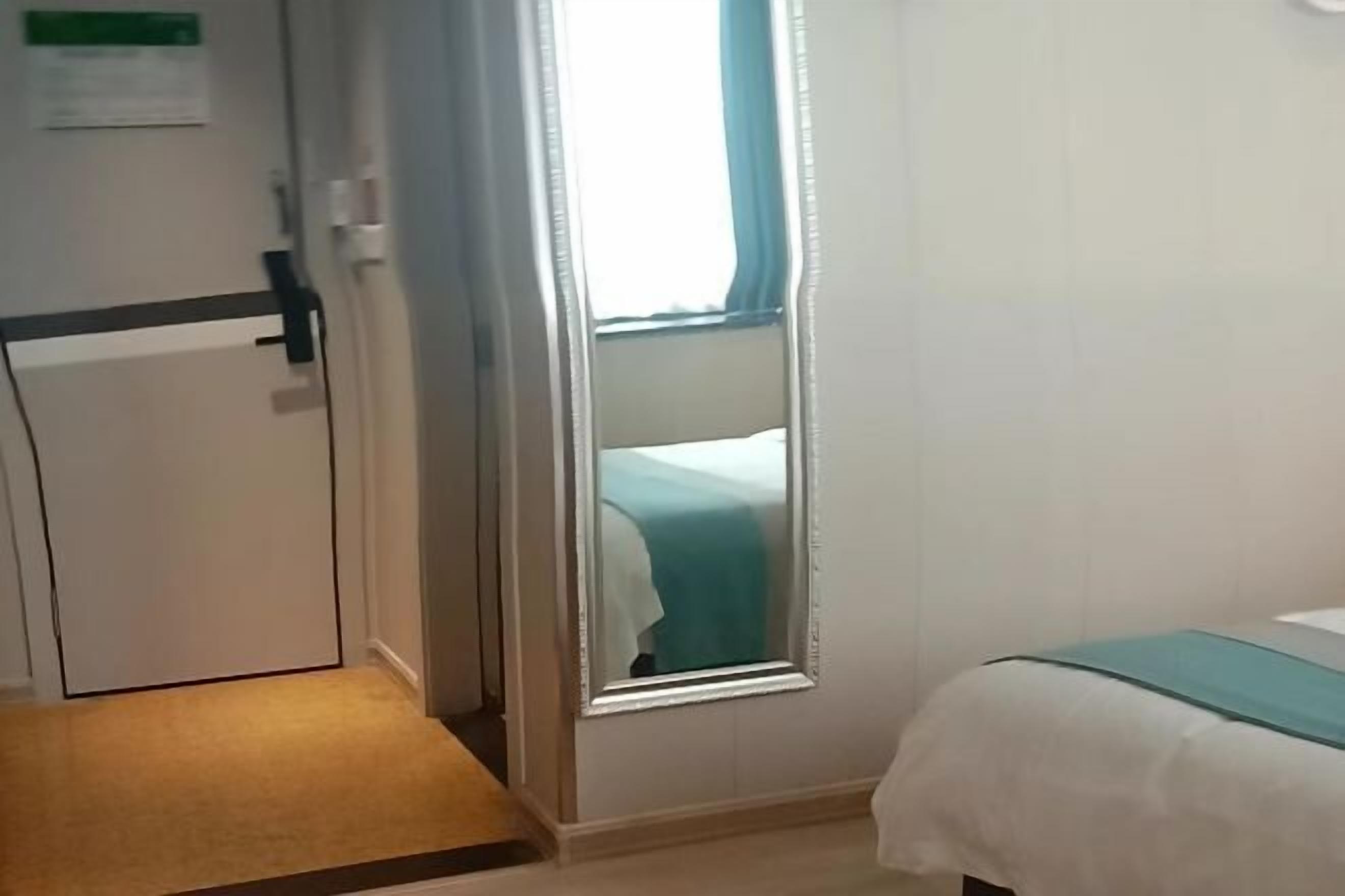 Une chambre d’hôtel avec un lit, une porte et une fenêtre.