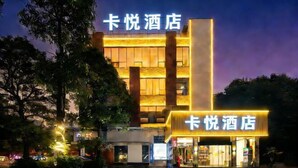 Un hotel con facciata moderna e insegne illuminate.