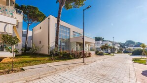 Un edificio moderno con tejado plano, ventanas amplias y un balcón con barandilla.