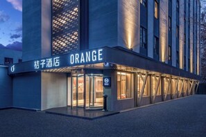 En hotelindgang med et skilt der siger 'ORANGE' og en drejeomdrejningsdør.