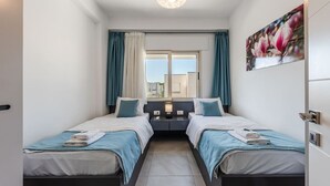 A twin room with two beds, a window with curtains, a painting on the wall, and a ceiling light. - Tranquil Apartment with pool access - Manjola by PikHost (Gjiri i Lalzit)