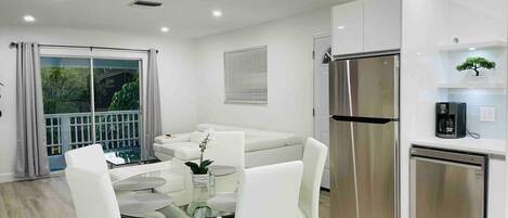 A modern kitchen with a stainless steel refrigerator, a dishwasher, and a coffee machine.