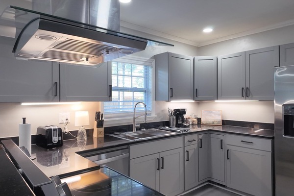 Modern kitchen with sleek stainless steel appliances, fully equipped for cooking and dining. Perfect for extended stays