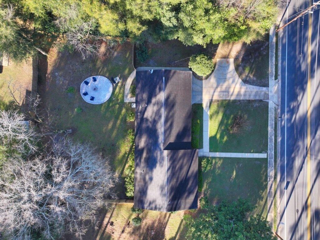 Vue aérienne d’une propriété dotée d’une allée pavée, d’un patio circulaire et d’une pelouse rectangulaire.