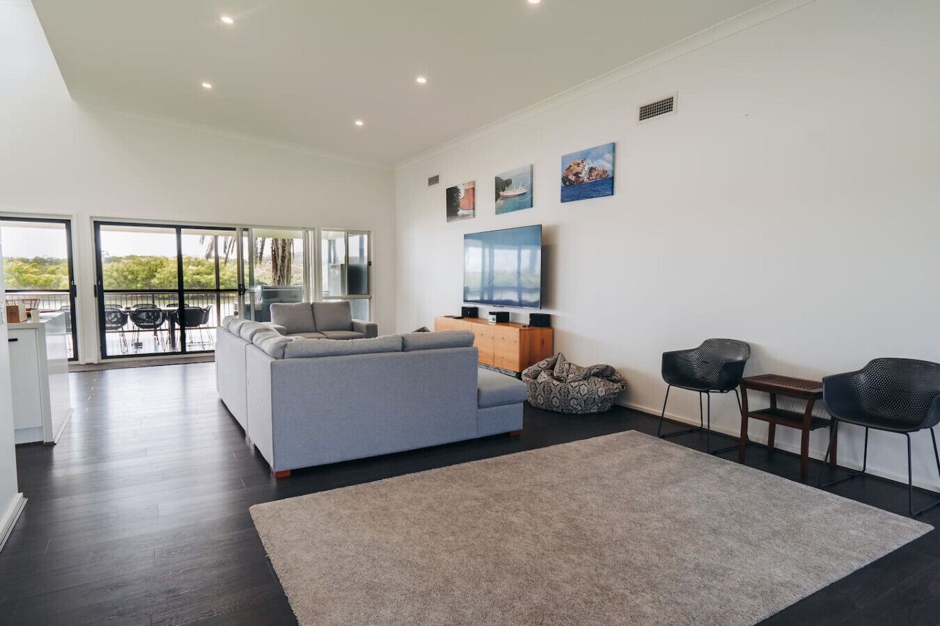 Unwind in the open living area with a large, comfortable sofa, Smart TV, and side chairs – ideal for movie nights or quiet afternoons.