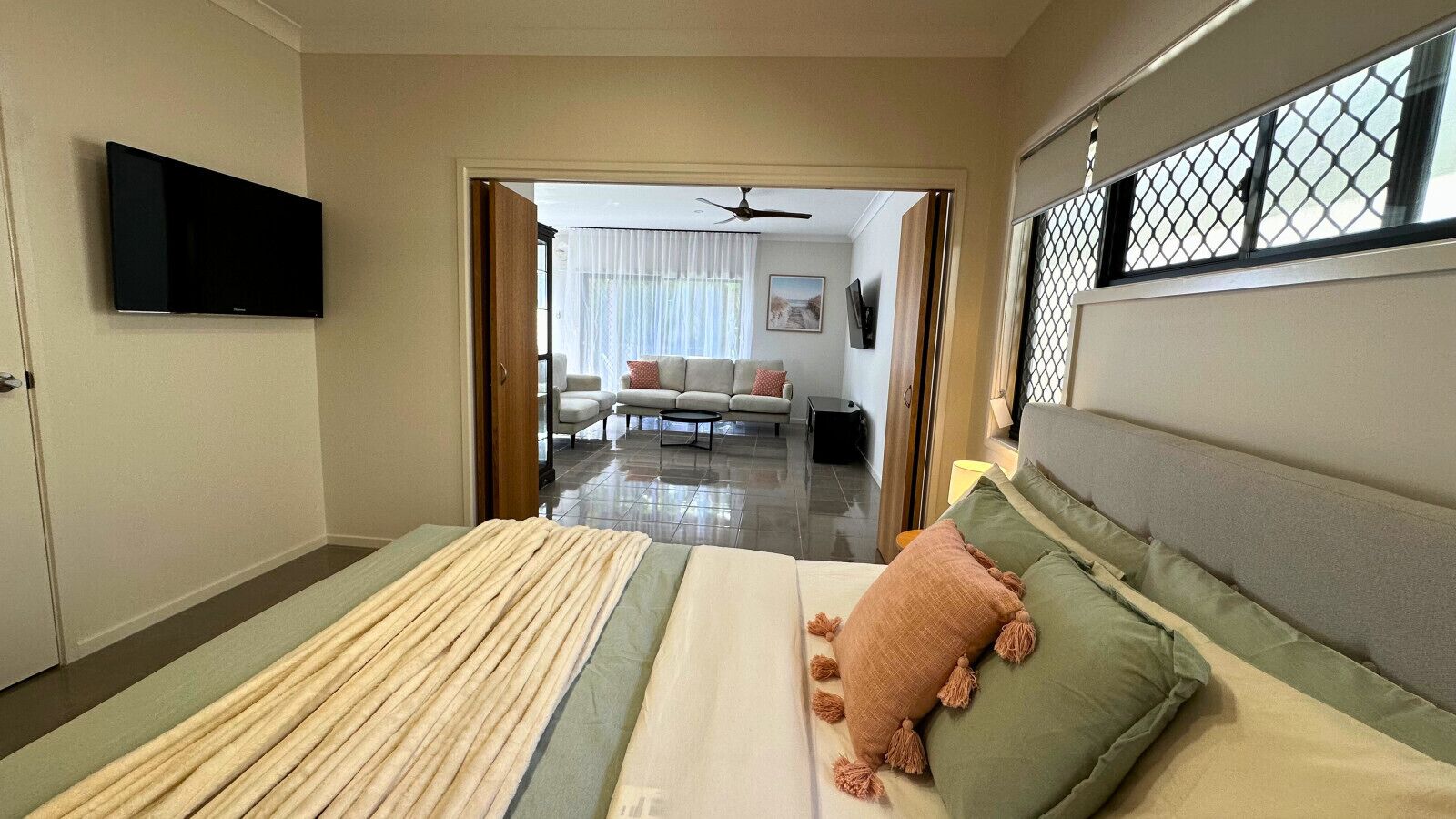 Bedroom One Relax in a cozy queen-size bed with soft linen, ceiling fan, side table and lamp, plus a Smart TV for your entertainment.