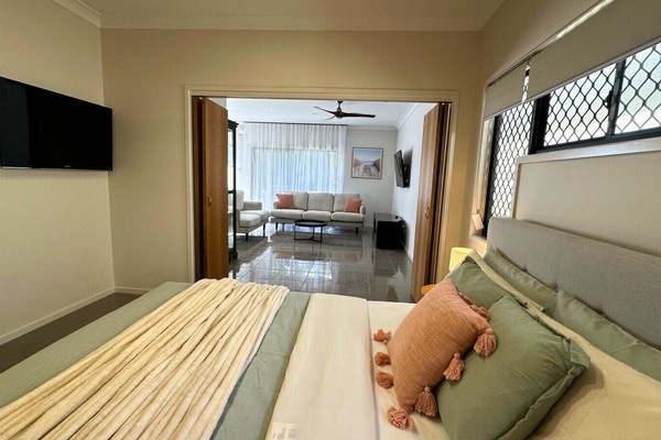 Bedroom One Relax in a cozy queen-size bed with soft linen, ceiling fan, side table and lamp, plus a Smart TV for your entertainment.