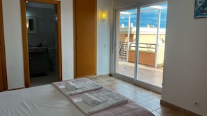 A hotel room with a bed, a bathroom, and a balcony with a view. - Jacaranda in Pedreguer (Pedreguer)